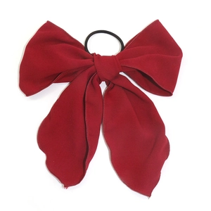 Solid deep red bow hair scrunchie with long ribbons made of textured chiffon fabric