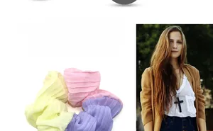 Close-up of three pleated chiffon scrunchies in pastel yellow, pink, and purple colors