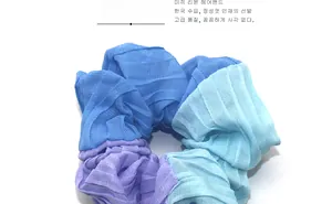 Close-up of tricolor chiffon scrunchie with soft pleated texture in purple and blue tones
