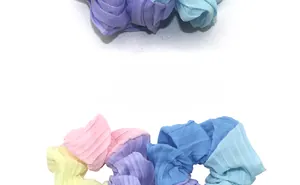 Detailed view of candy-colored pleated chiffon hair scrunchies with soft pastel textures
