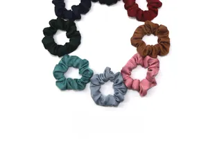 Primo piano di otto elastici per capelli in raso in vari colori come nero, blu e bordeaux