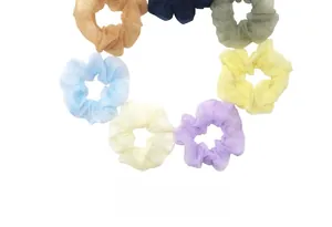 Detail view of colorful organza scrunchies in various shades like green, blue and beige