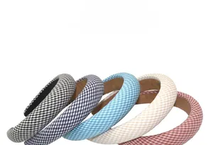 Detailed view of thick padded plaid headbands in various colors with soft fabric texture