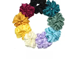 Flat lay detail showing nine assorted colors of large elastic satin silk hair scrunchies