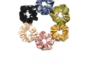 Détail de six chouchous en soie colorés avec motifs marguerites blanches en vue à plat