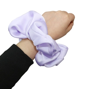 Fashionable oversized lavender satin scrunchie with silky folds worn on wrist