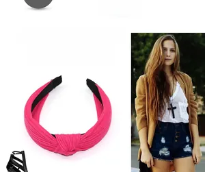 Détail d'un serre-tête rose en coton tricoté avec un design élégant à nœud croisé
