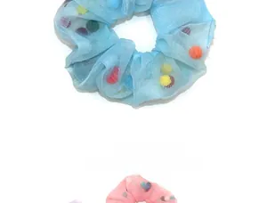 Détail du chouchou en organza rempli de pompons en peluche colorés doux