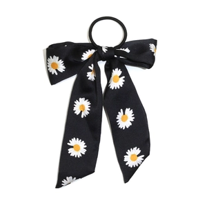 Floral black ribbon hair scrunchie with daisy print and satin finish on white background