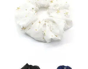 Vue détaillée des chouchous en mousseline étoilée en blanc, noir et bleu marine