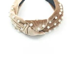 Detail of camel velvet headband featuring elegant pearl embellishments and a top knot design