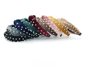 Detailed view of assorted velvet knot headbands with elegant pearl embellishments