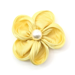 Barrette à fleurs en tissu jaune élégante avec perle centrale sur fond blanc uni