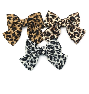 Détails des barrettes à nœuds en velours à motif léopard en trois tons sur blanc