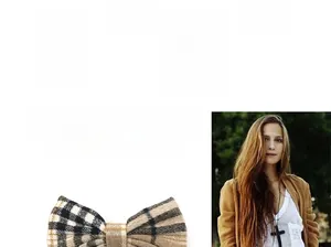Detail of vintage plaid bow hair clip with classic brown check fabric and elegant texture