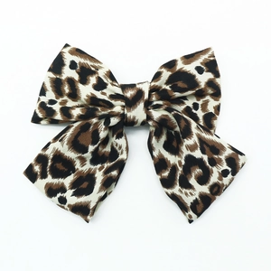 Pince à cheveux nœud papillon oversize à imprimé léopard en tissu sur fond blanc neutre