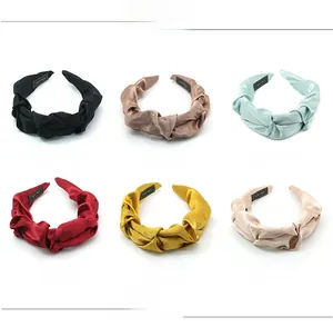 Detail view of 6-piece pleated satin headband set showing hand-made woven labels