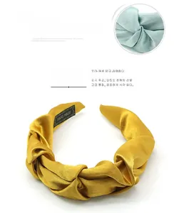 Close-up of pleated satin headband featuring handmade woven texture and silk-like finish