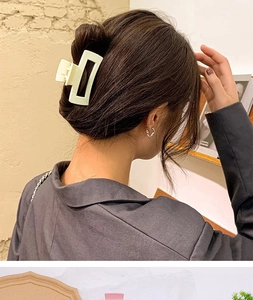 Detail view of a matte cream rectangular hair claw clip styling a sleek bun hairstyle