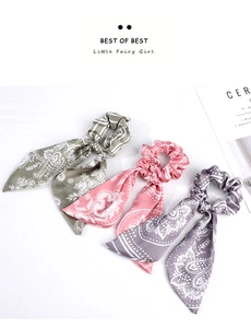 Close-up of three long ribbon paisley hair scrunchies in green, pink and purple silk