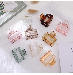 Detailed view of nine assorted semi-transparent rectangle claw clips on white paper