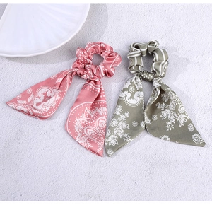 Close-up of pink and green floral silk ribbon scrunchies set with paisley pattern