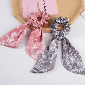 Pink and grey vintage paisley bow hair scrunchies with long ribbons on a tray