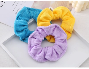 Close-up of soft candy-colored towel fabric hair scrunchies in blue, yellow, and violet