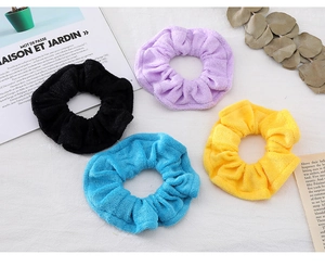 Detail view of 4-pack candy colored terry cloth scrunchies in purple black yellow and blue