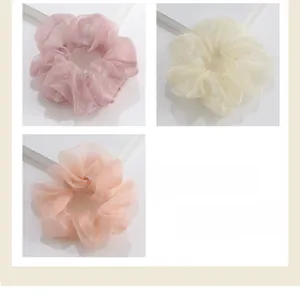 Vue détaillée de chouchous en tulle transparent de couleurs rose, beige et orange clair