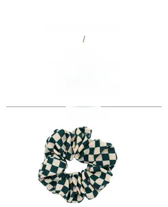 Close-up of retro checkered hair scrunchie in dark green and cream woven fabric