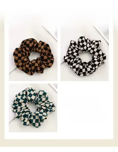 Detailed set of three checkered hair scrunchies in brown, black, and green fabric textures