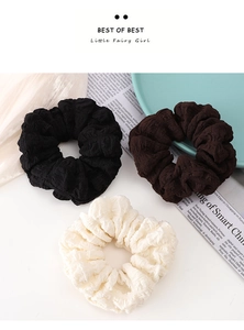 Ensemble détaillé de chouchous en tricot noir, marron foncé et crème à texture plissée