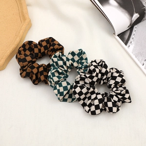 Three-piece set of checkerboard pattern scrunchies in brown, green, and black fabric