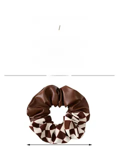 Detail view of checkers and brown leather scrunchie with 11cm diameter measurement