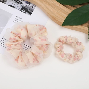 Floral mesh scrunchie set in beige and pink organza on a rustic wooden tray