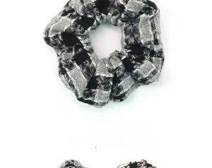 Détail de la texture d'un chouchou en tricot à carreaux noir et blanc à tissage doux