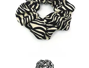 Close-up of zebra pattern fabric scrunchie showing detailed textile texture and pleats