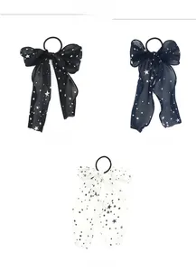 Detail view of chiffon bow hair ties featuring star patterns in black, navy, and white