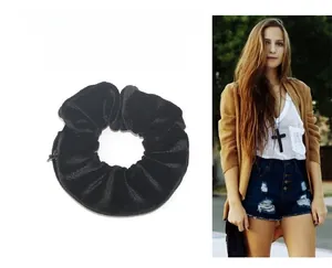 Detail of black velvet scrunchie featuring a hidden zipper pocket and soft pleated texture