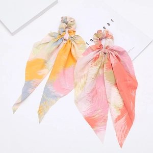 Pair of bohemian printed ribbon hair scrunchies with vibrant artistic patterns on white background