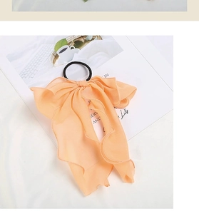 Detail of apricot chiffon bow hair tie with high-elastic black rubber band on card