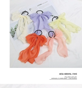 Flat lay of colorful chiffon bow hair ties with long streamers in five soft pastel shades