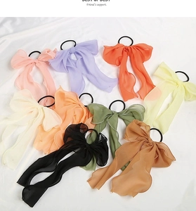 Close-up of nine colorful chiffon bow scrunchies with long ribbons on white background