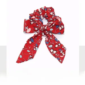 Detail showing red floral fabric scrunchie with white flower pattern and bow detail