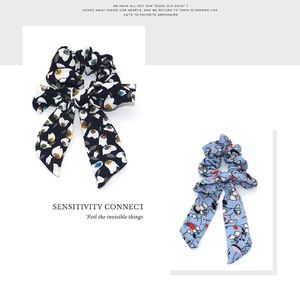 Close-up of floral print chiffon scrunchies with long ribbons in navy and blue