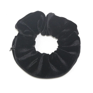Black velvet scrunchie with hidden zipper pocket for small items storage on white background