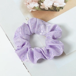 Close-up of a purple glitter fabric scrunchie with sparkling silver shimmer texture