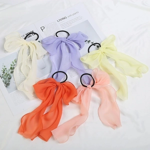 Five-piece set of chiffon bow hair ties in assorted pastel colors on a soft fabric base