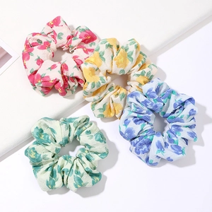 Floral print scrunchies set in four colors displayed on clean white steps